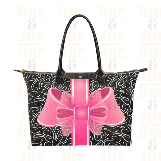 Zip top fashion tote bag with a big pink bow on a black with white abstract background.